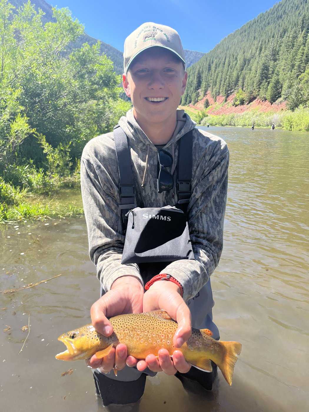 Holding a golden trout in a mountain river
